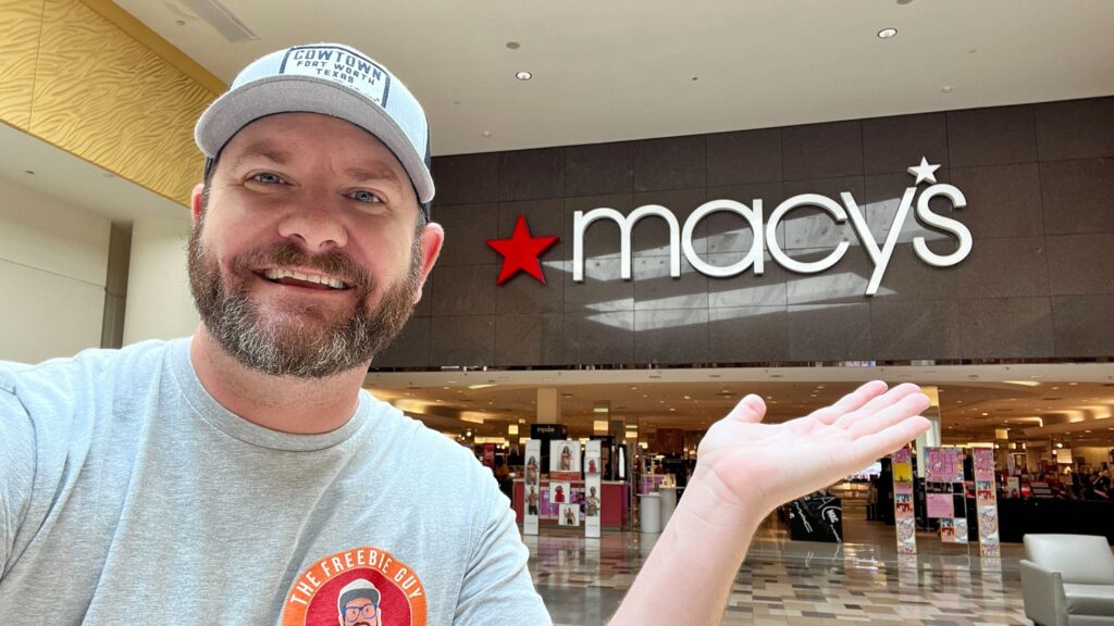 Kendall holding his hand out in front of Macy's store