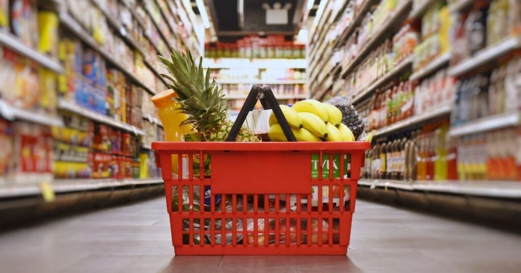 shopping basket with food in it in a store aisle