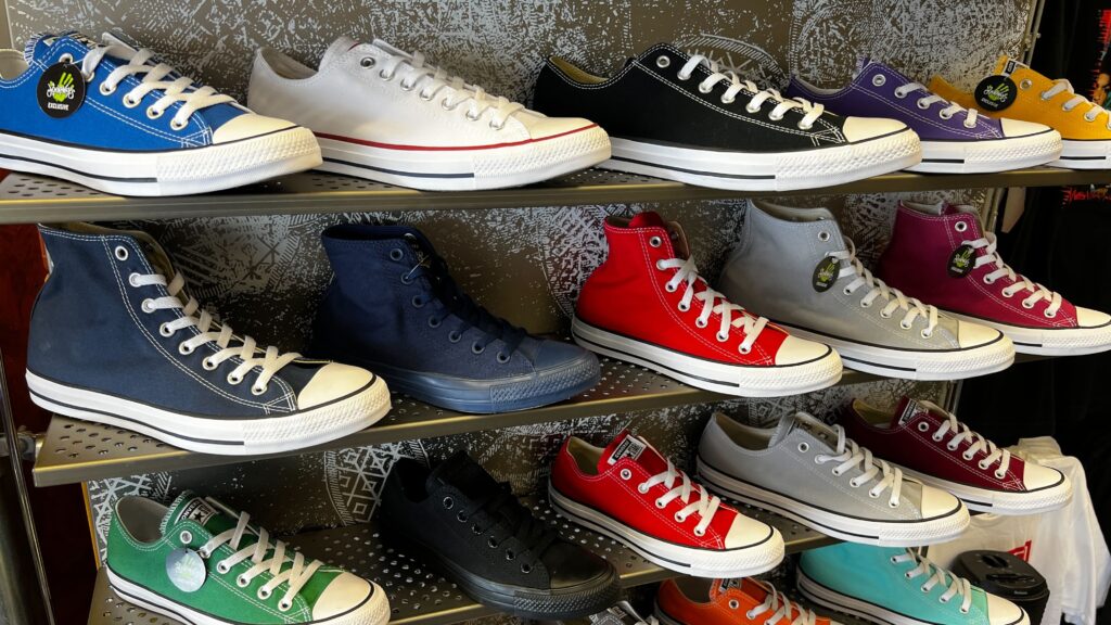 rows of Converse shoes on shelves at a store