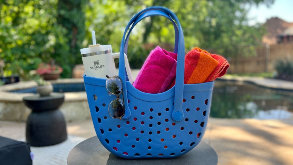 pool bag with towels in it and sunglasses by pool