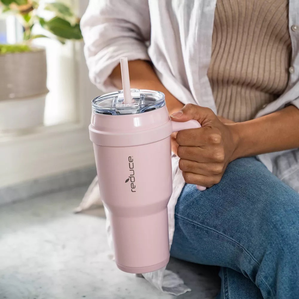 woman holding a reduce tumbler