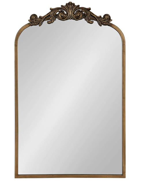 mirror with gold sides and a flourish on the top