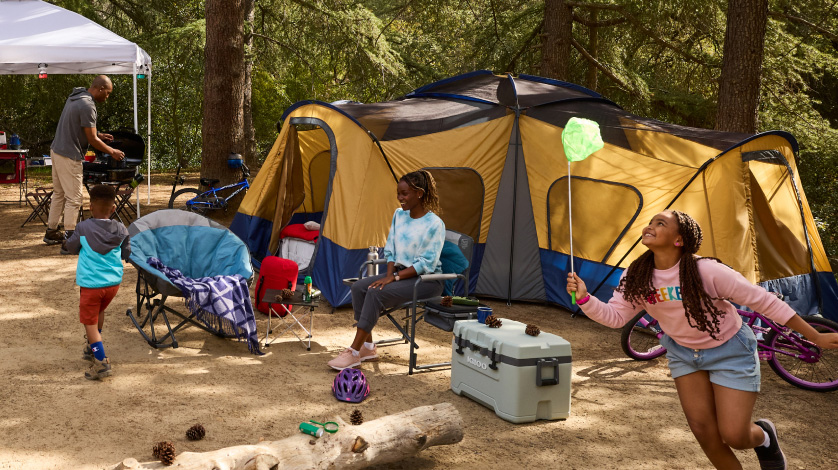 kids running around a tent at a campsite