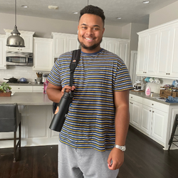 college age student standing in kitchen with bag