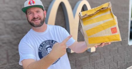 kendall (The Freebie Guy) holding a McDonald's sack. Sharing the best McDonald's deals today.