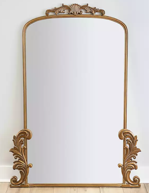 mirror with gold edging and flourish on the top