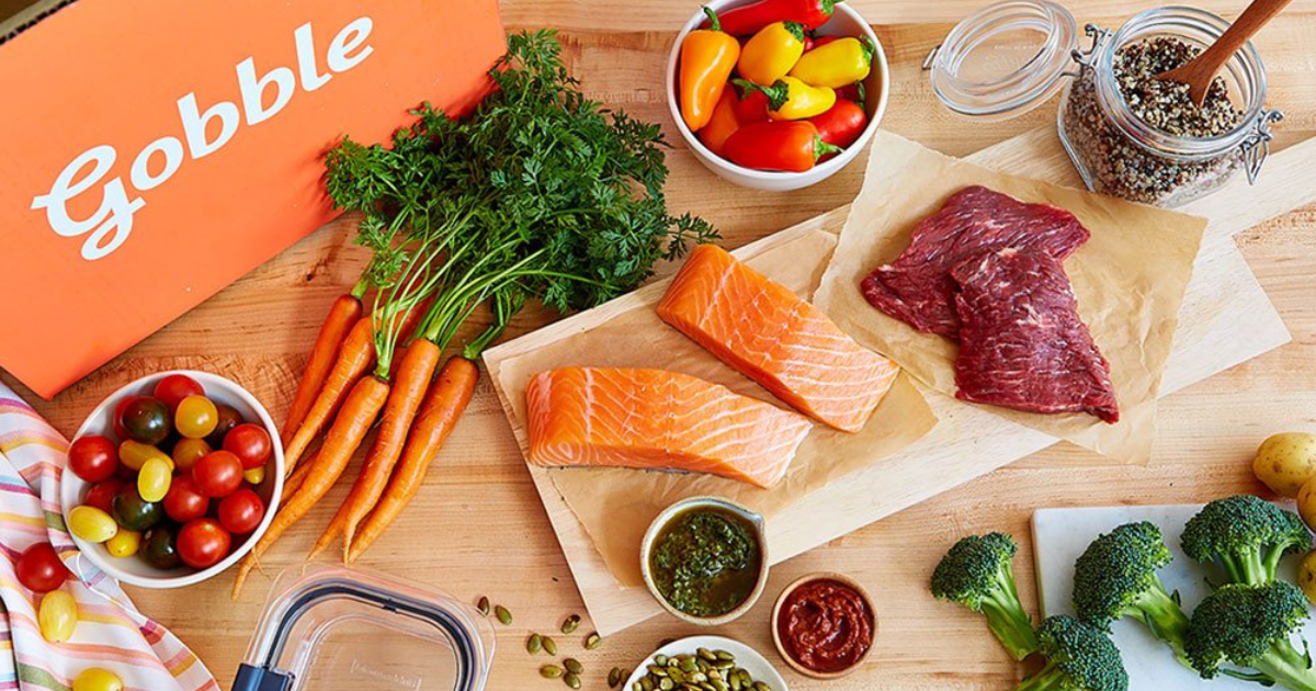 Orange box with Gobble on the side on a table with food and vegetables around it