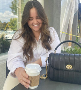 lady sitting outside with purse and coffee