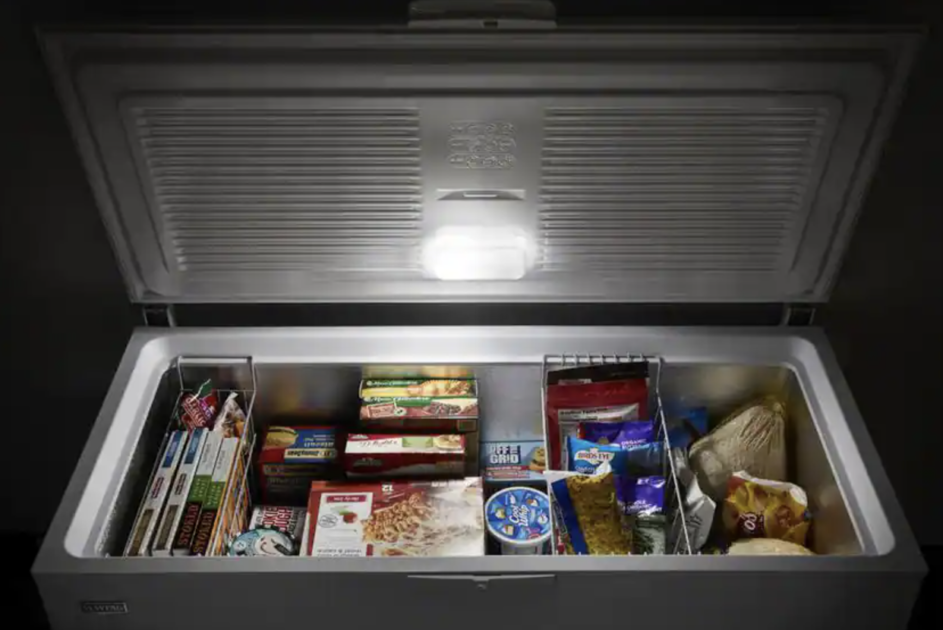 chest freezer with the lid open, light on the lid, and food inside