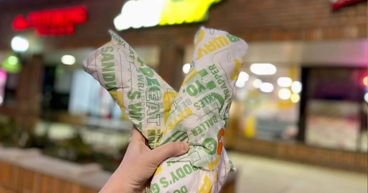 kendall bogo subway deal Hand holding two subway sandwiches in side of the subway store