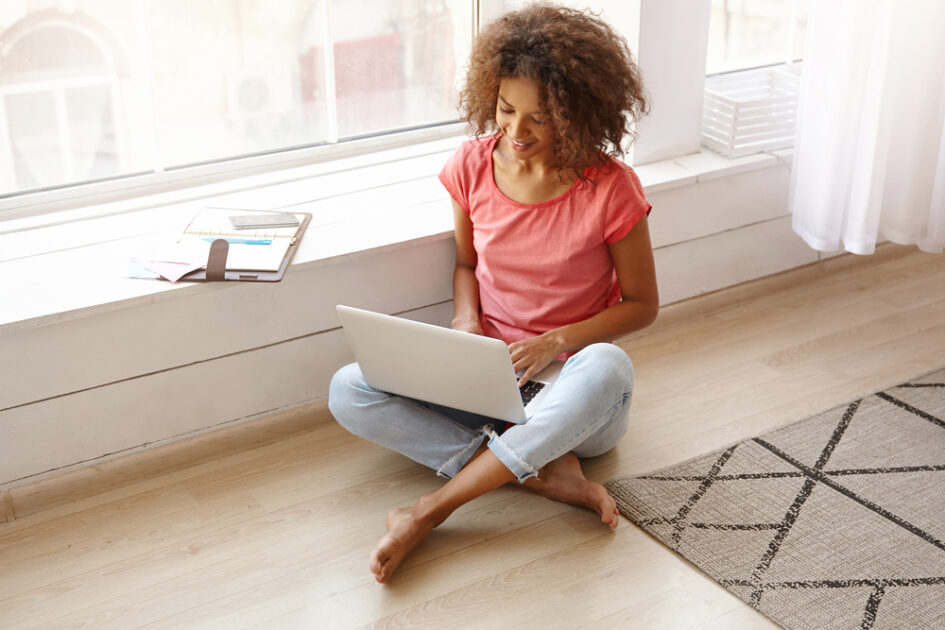 woman sitting on the floor with a laptop in her lap