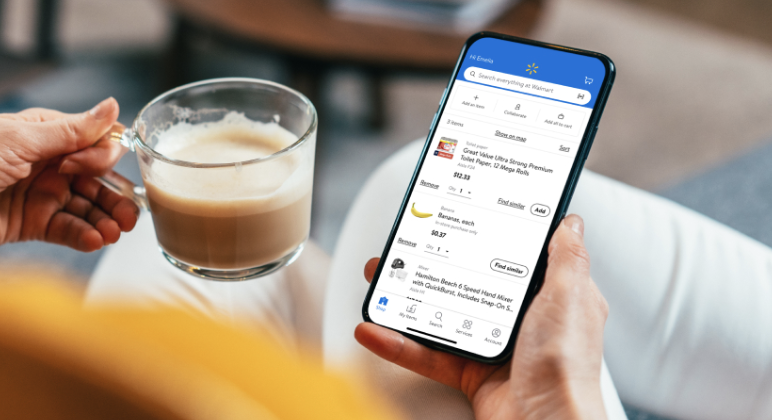 cup of coffee in left hand and iphone on the walmart app in right hand
