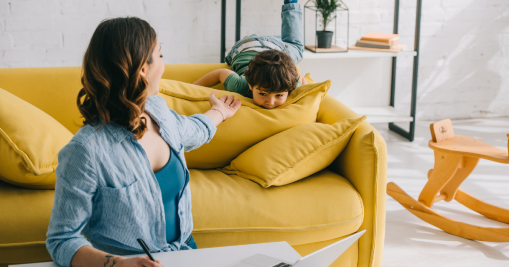 woman holding out a hand to a boy on a couch