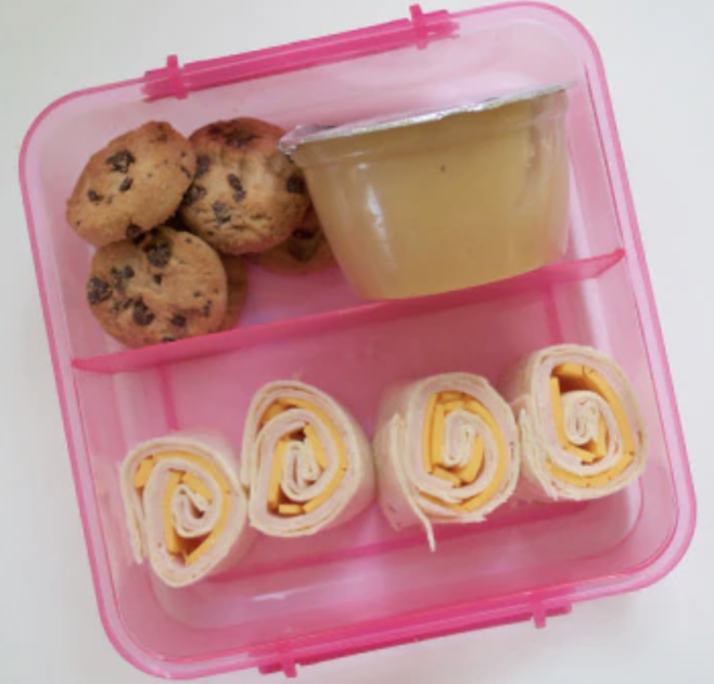 pink lunchbox with food inside