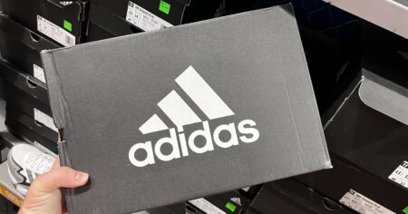 Hand holding an adidas shoe box