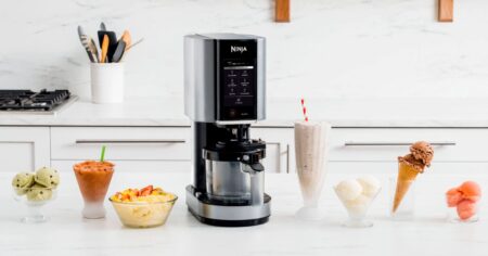 Ninja Creami on a countertop surrounded by ice cream, milkshakes, and other desserts