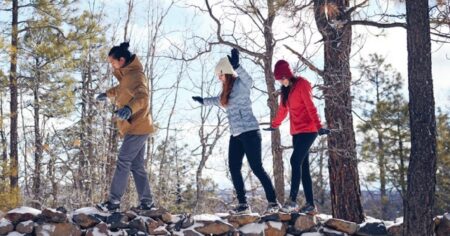 three people walking in the woods