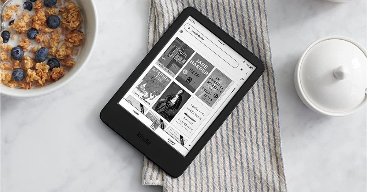 kindle with Kindle Unlimited app open on a table with a bowl of cereal