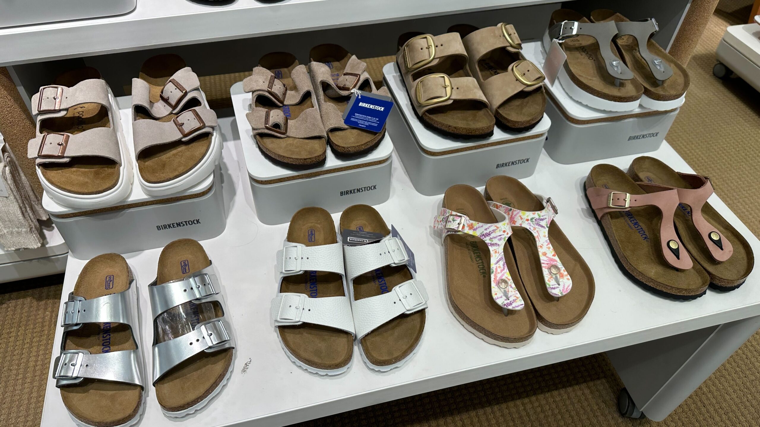 two rows of Birkenstock sandals on a display table