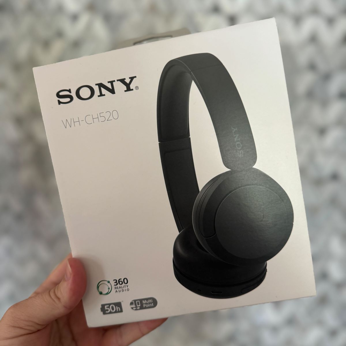 Sony WH CH520 Wireless Headphones with Microphone hand holding a box with Sony headphones