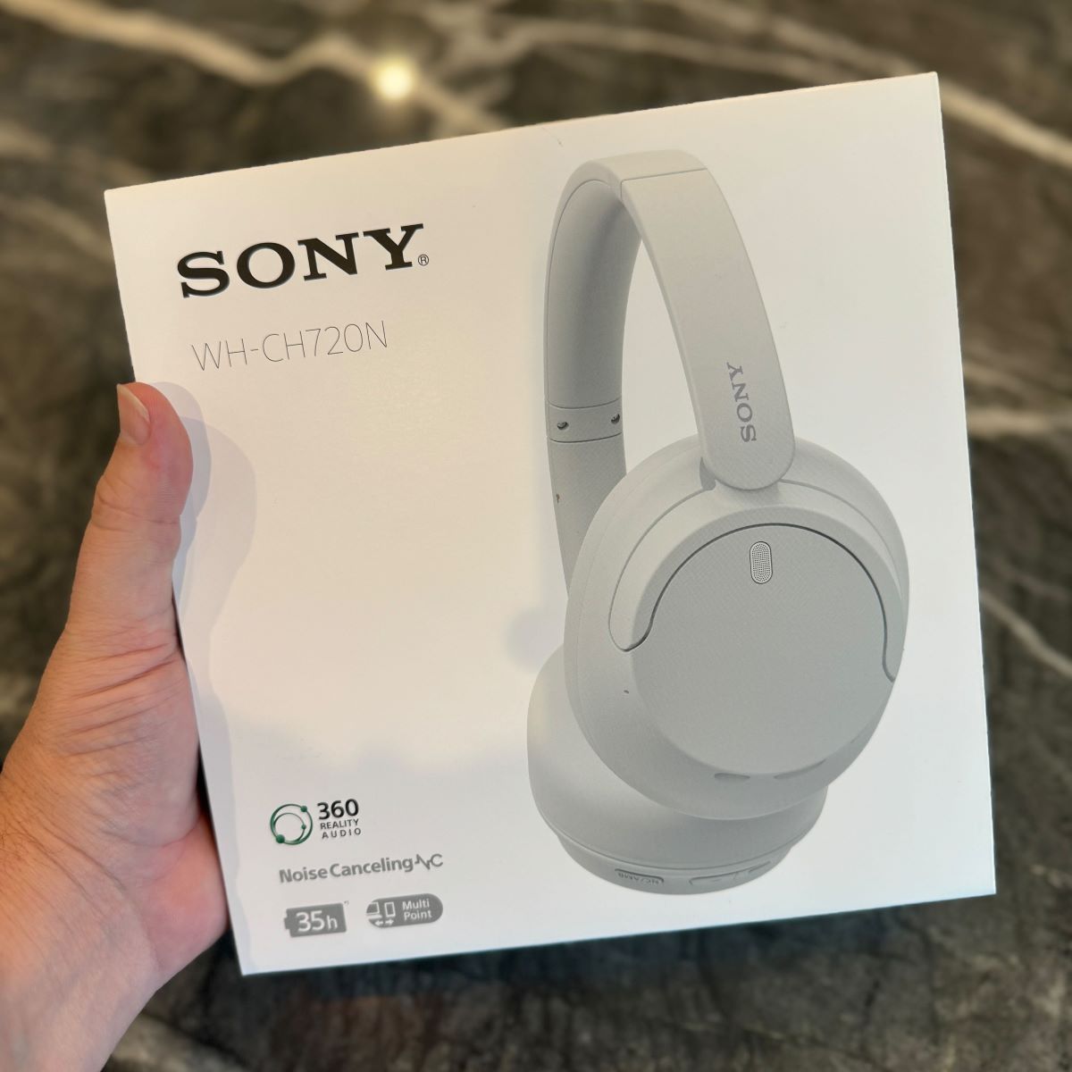 Sony WH CH720N Wireless Noise Canceling Headphone hand holding a Sony headphones box
