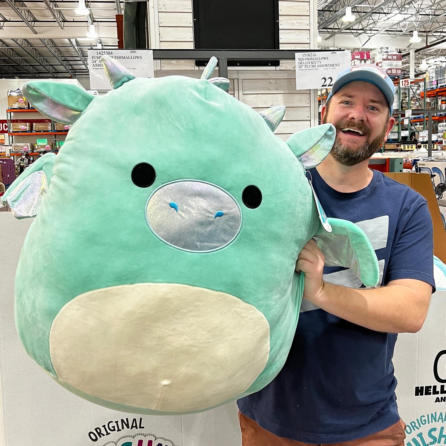 man holding a giant Squishmallow plush