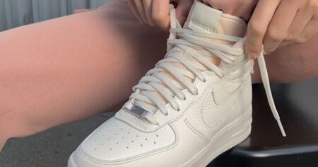 Person in Pink Leggings Laces Up White Nike Air Forces on Clearance