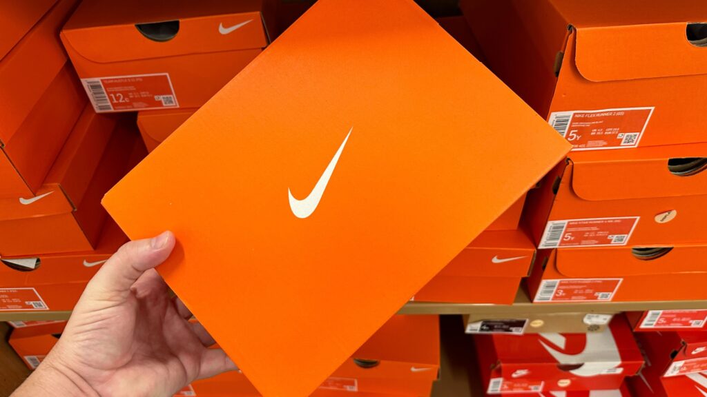 nike-in-store-image-box Person Holding Orange Nike Shoe Box in Nike Store with New Nike Shoe Drops and Clearance Deals