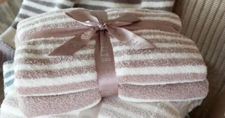 pink striped blanket folded up with a bow on it