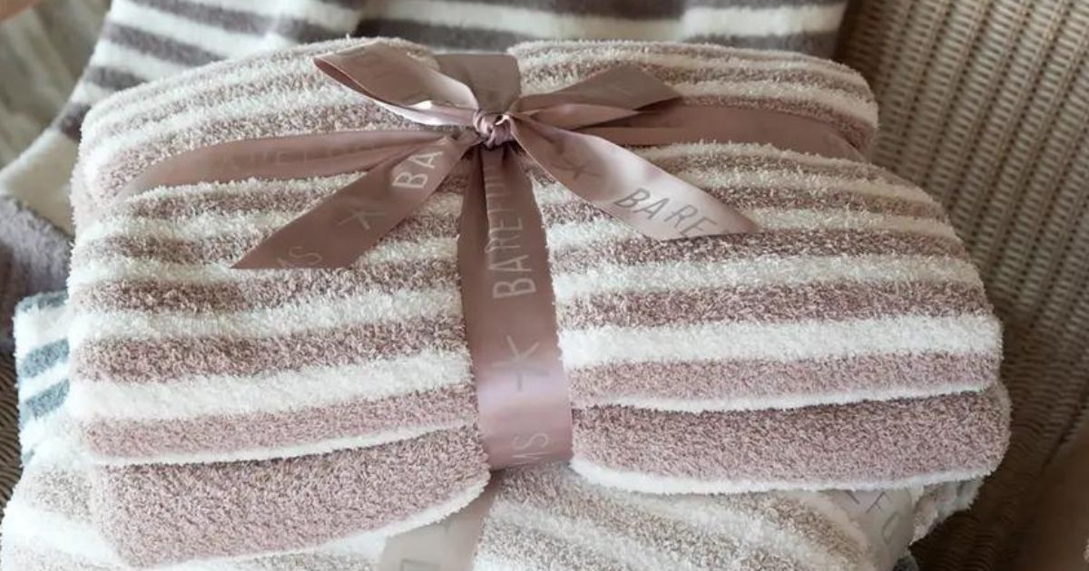 Barefoot Dreams pink striped blanket folded up with a bow on it