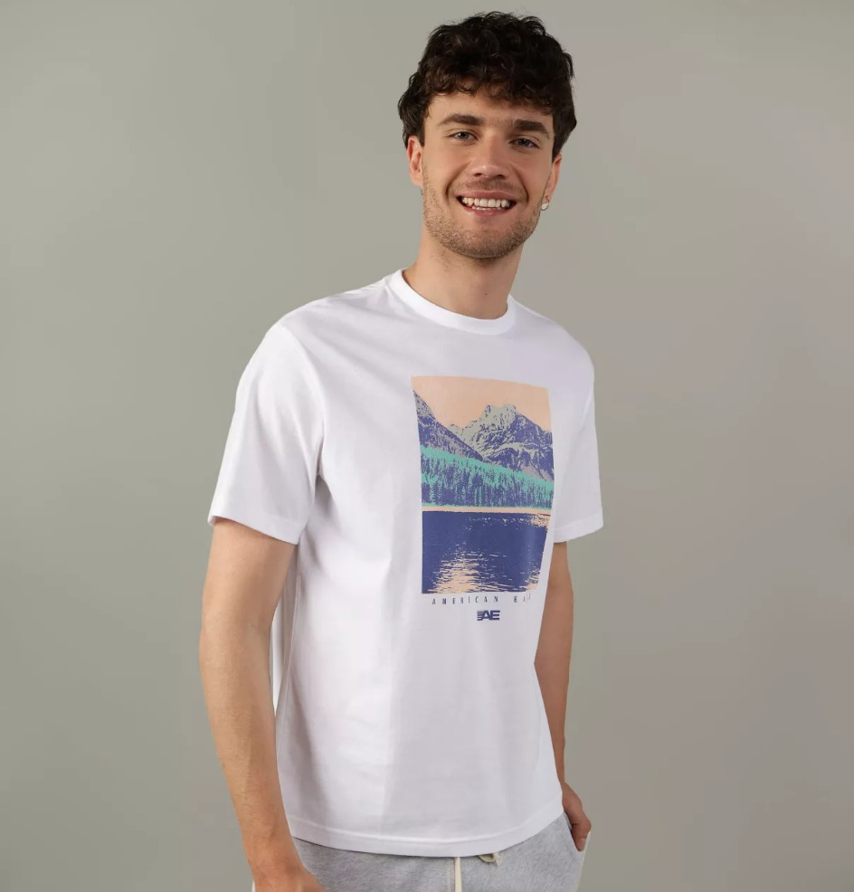 man smiling at the camera wearing a white graphic tee