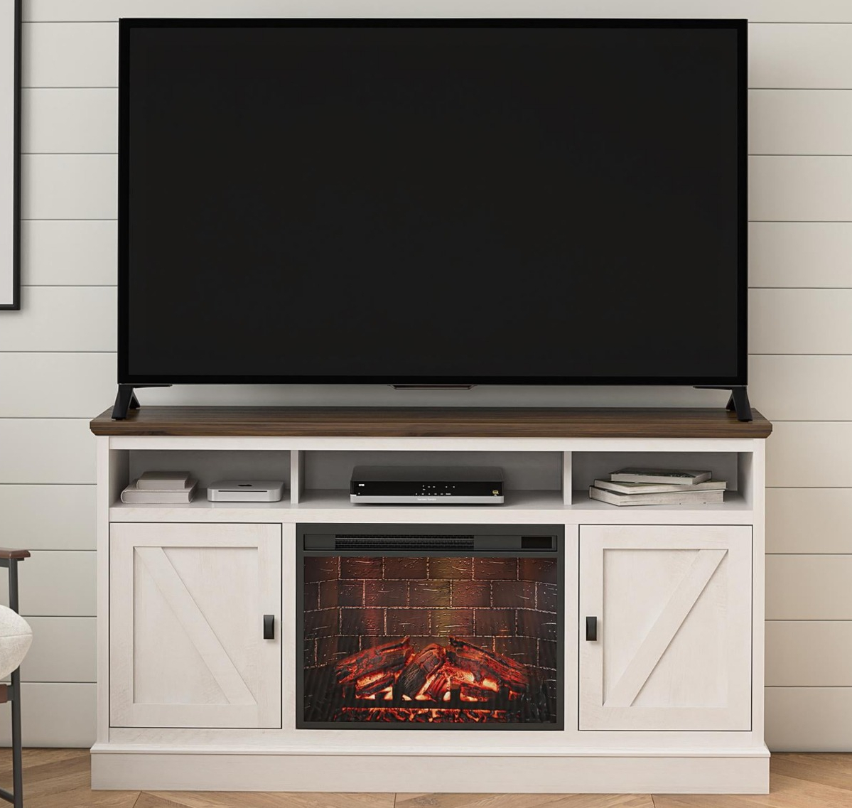 large TV on a white TV stand with a fireplace in the middle