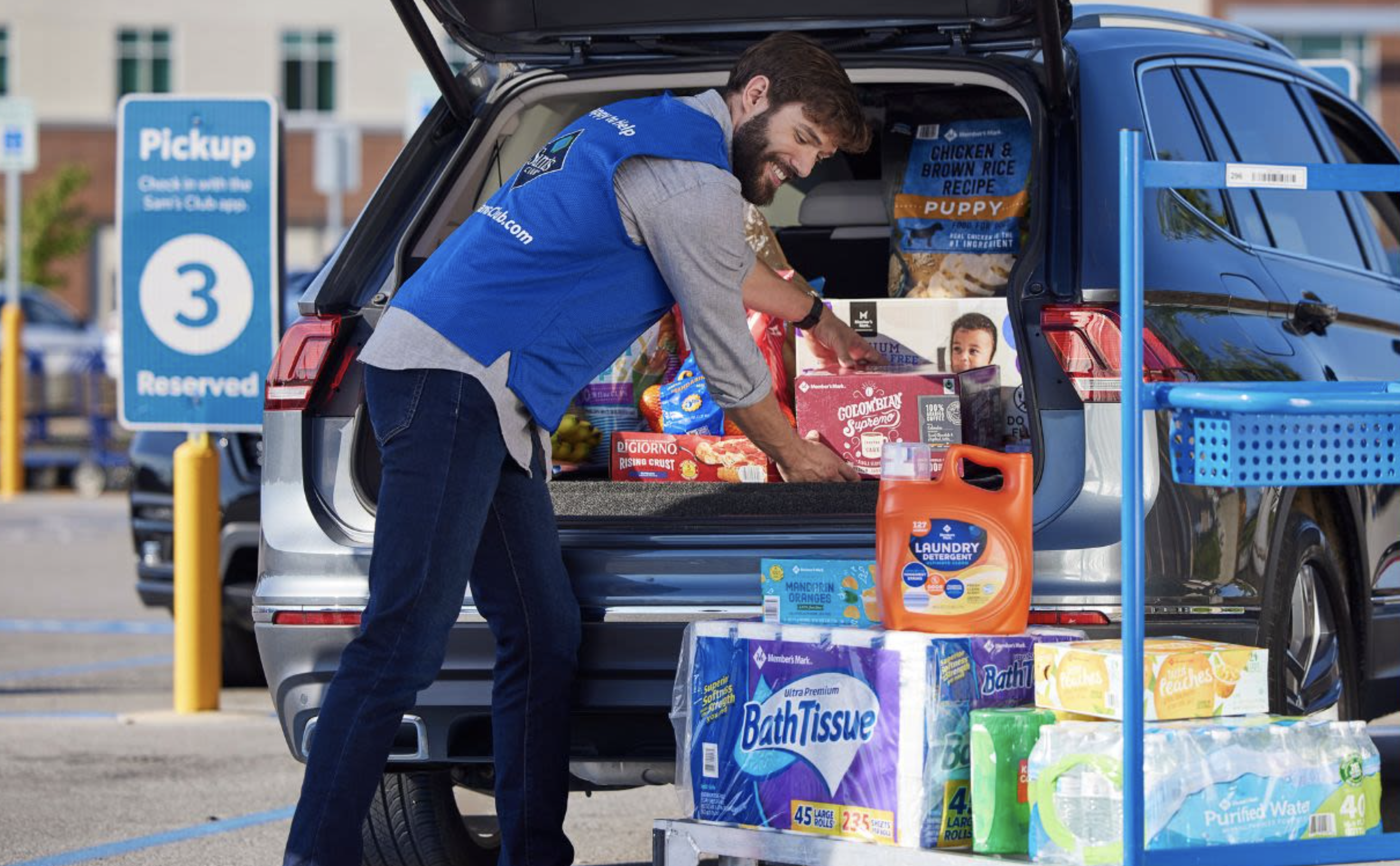 man loading groceries into the back of a car