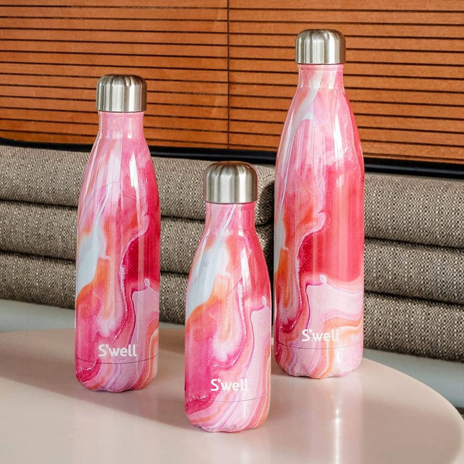 three S'well water bottles on a table