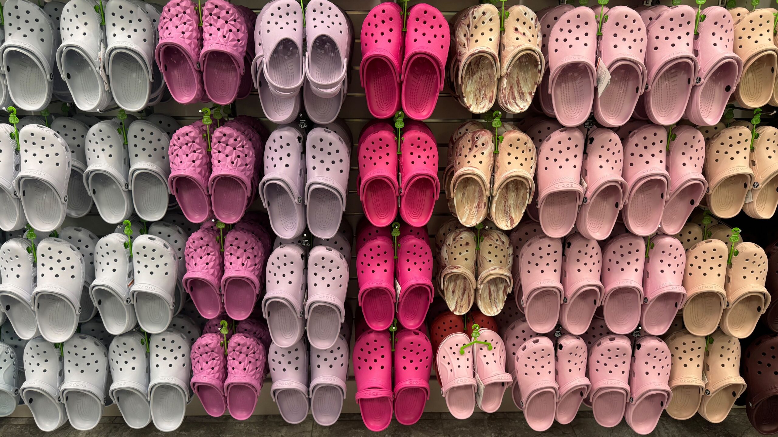 display of crocs hanging on wall with multiple color options