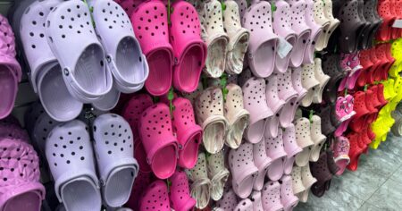 display of crocs hanging on wall with multiple color options