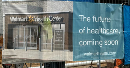 Walmart Health Center banner hanging on fence