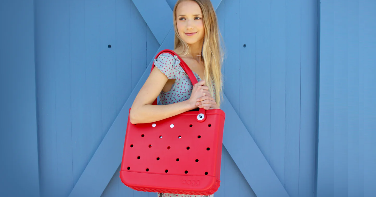 bogg bag sale moosejaw woman standing holding bogg bag in red
