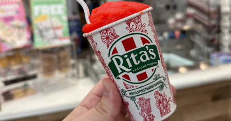 hand holding a small cup of Rita's ice custard with a spoon in the top of the ice