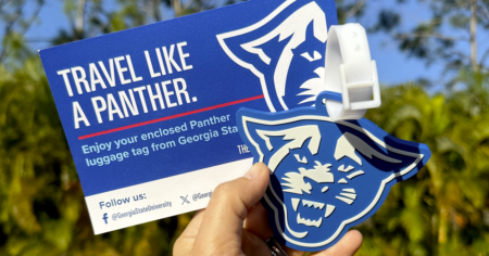hand holding panther luggage tag