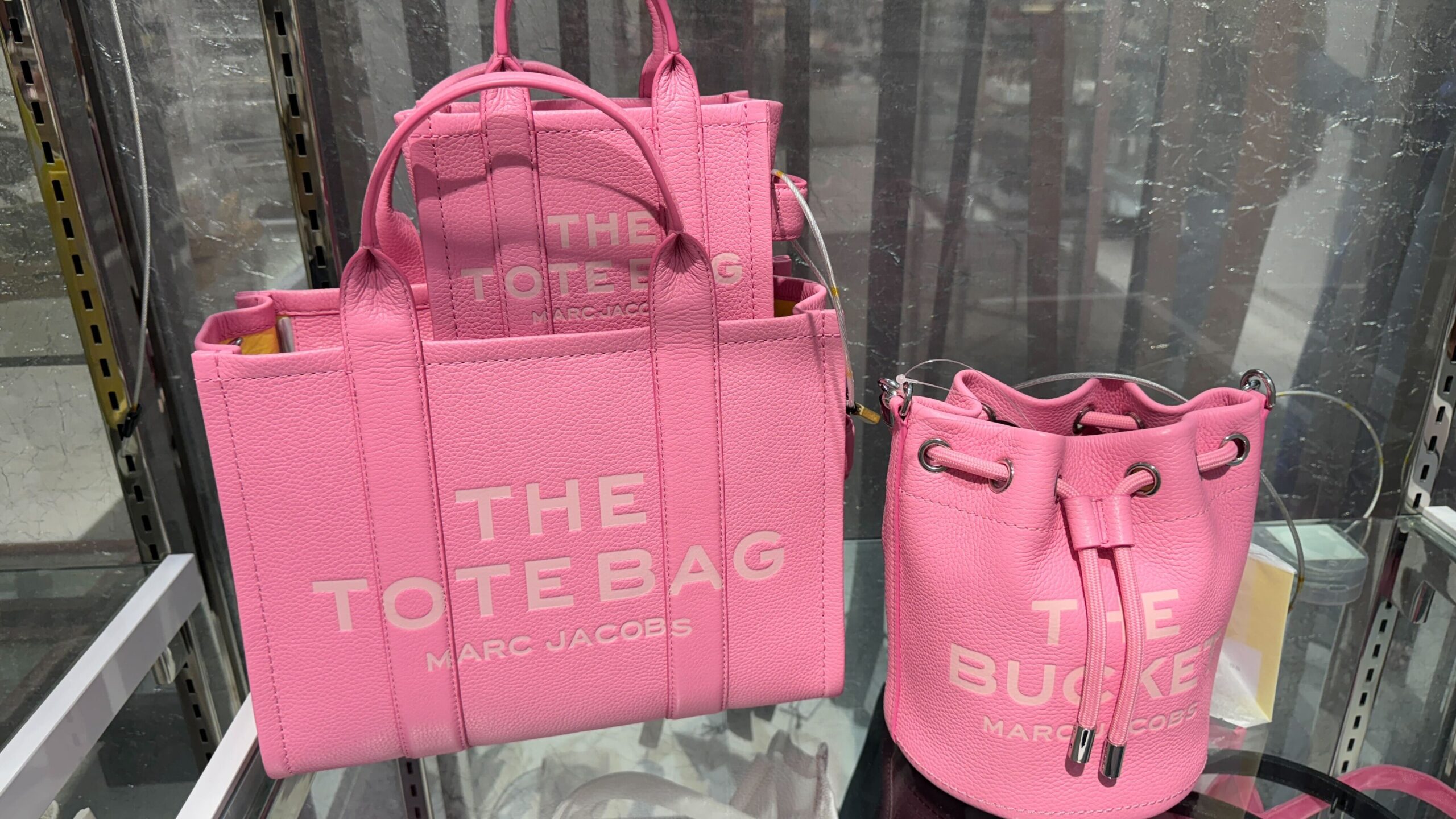 pink marc jacobs the tote bags sitting on a shelf