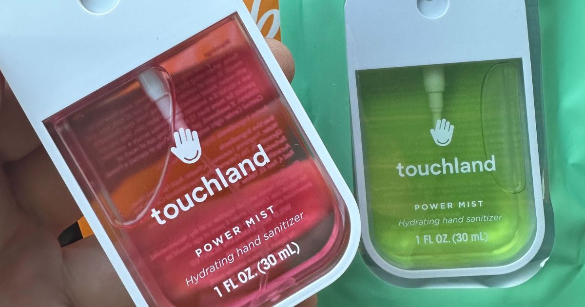 Touchland hand holding two Touchland hand sanitizers