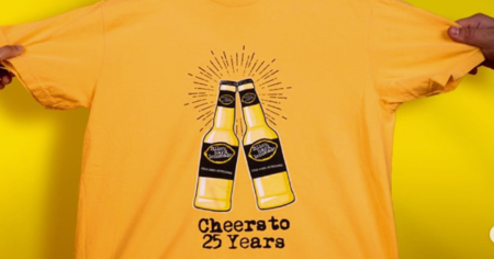 hands holding up a yellow shirt