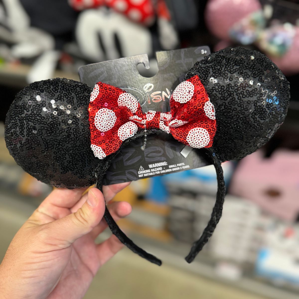 Disney Character Headbands hand holding a Minnie Mouse headband