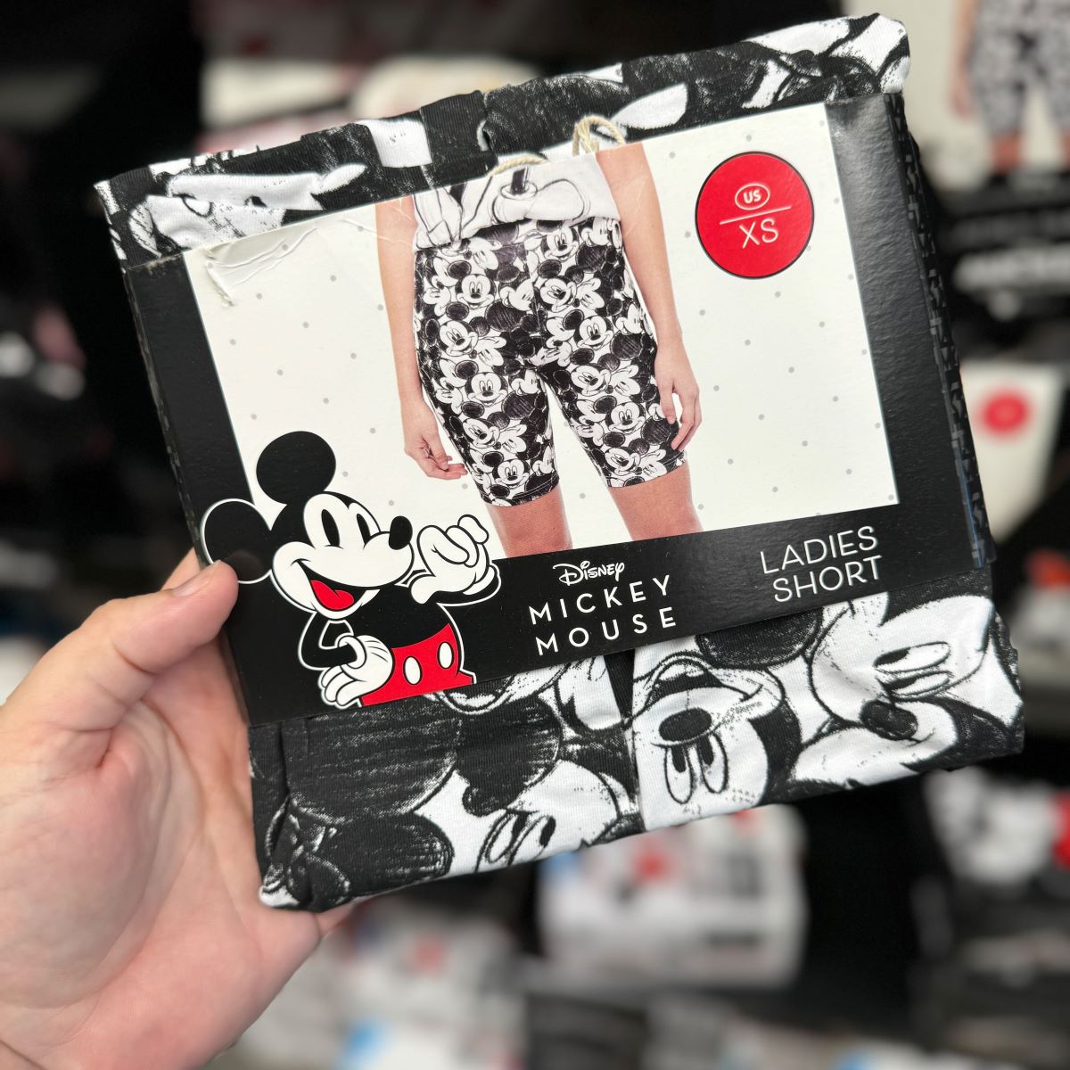 Disney Ladies Shorts hand holding a pair of women's shorts