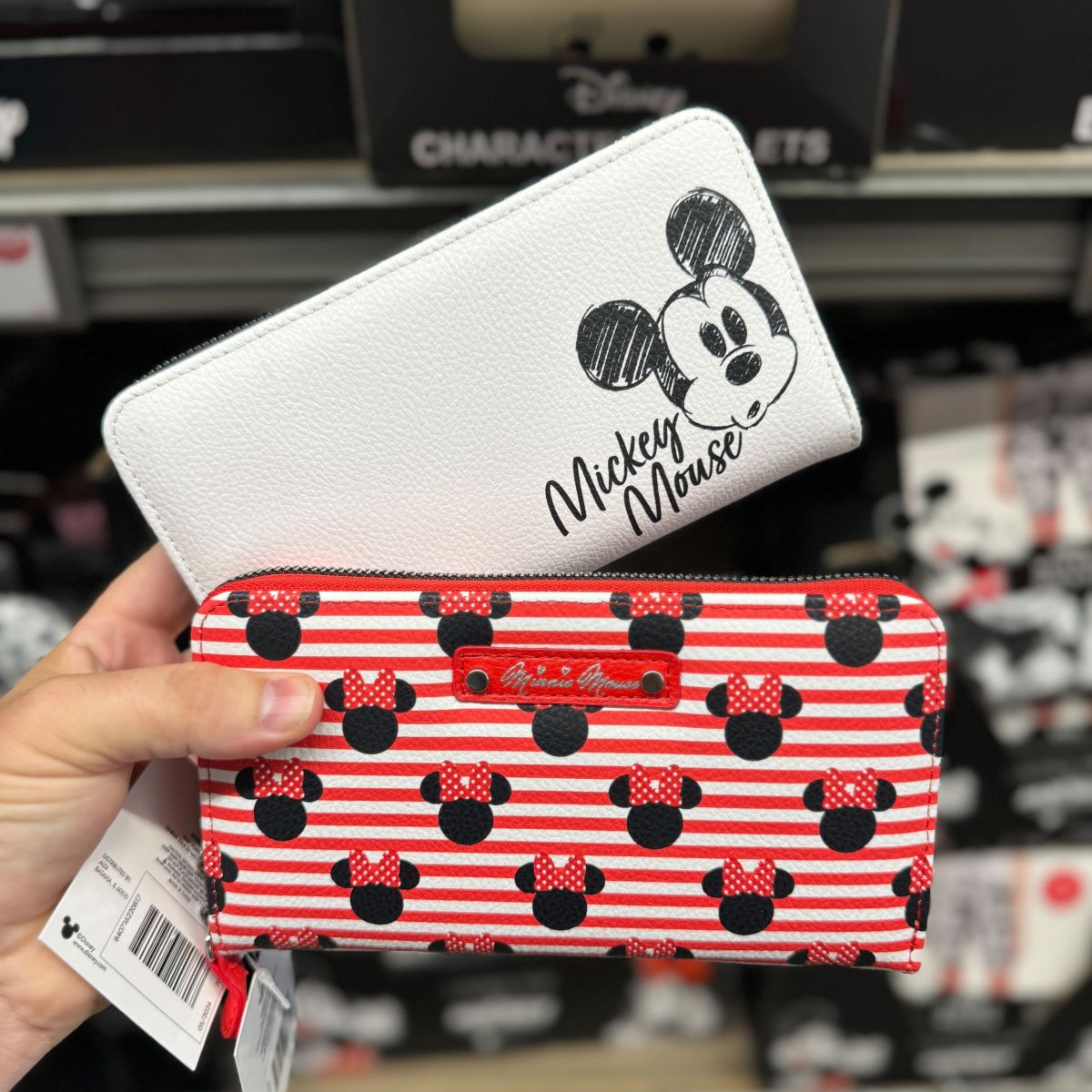 Disney Wallets hand holding two Disney wallets