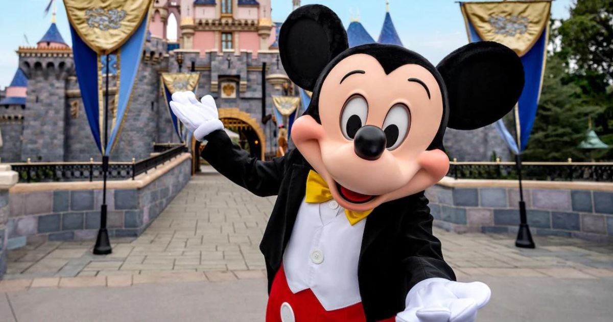 Disneyland Mickey Mouse standing in front of Disneyland castle