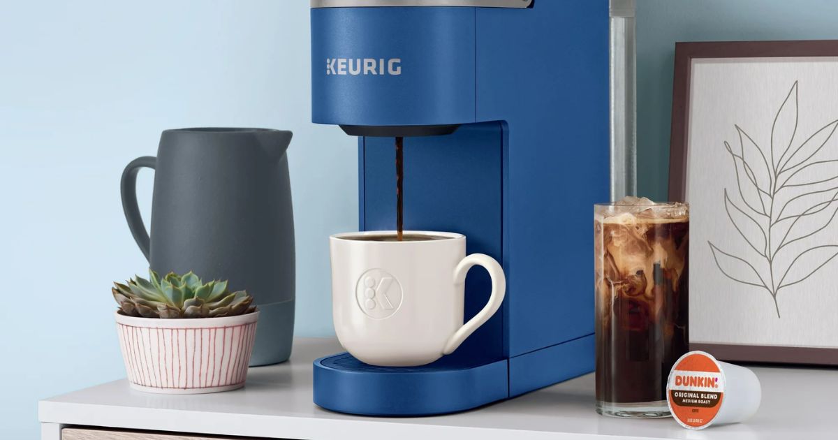 keurig coffee maker brewing into a cup with a cup of coffee next to it