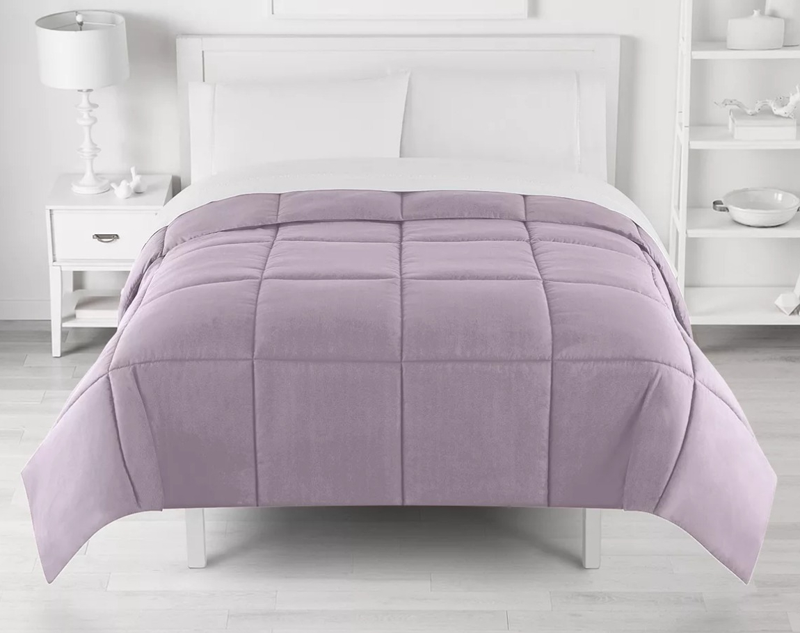 purple comforter on a bed
