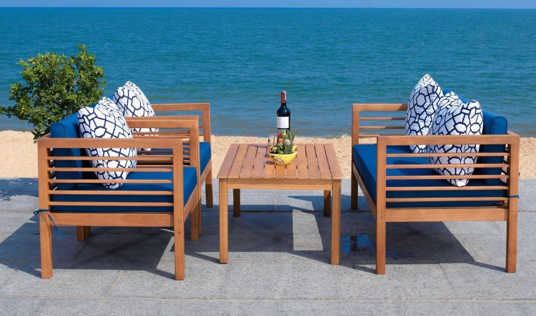 Arlethe Person Outdoor Seating Group with Cushions three patio chairs on a patio overlooking water